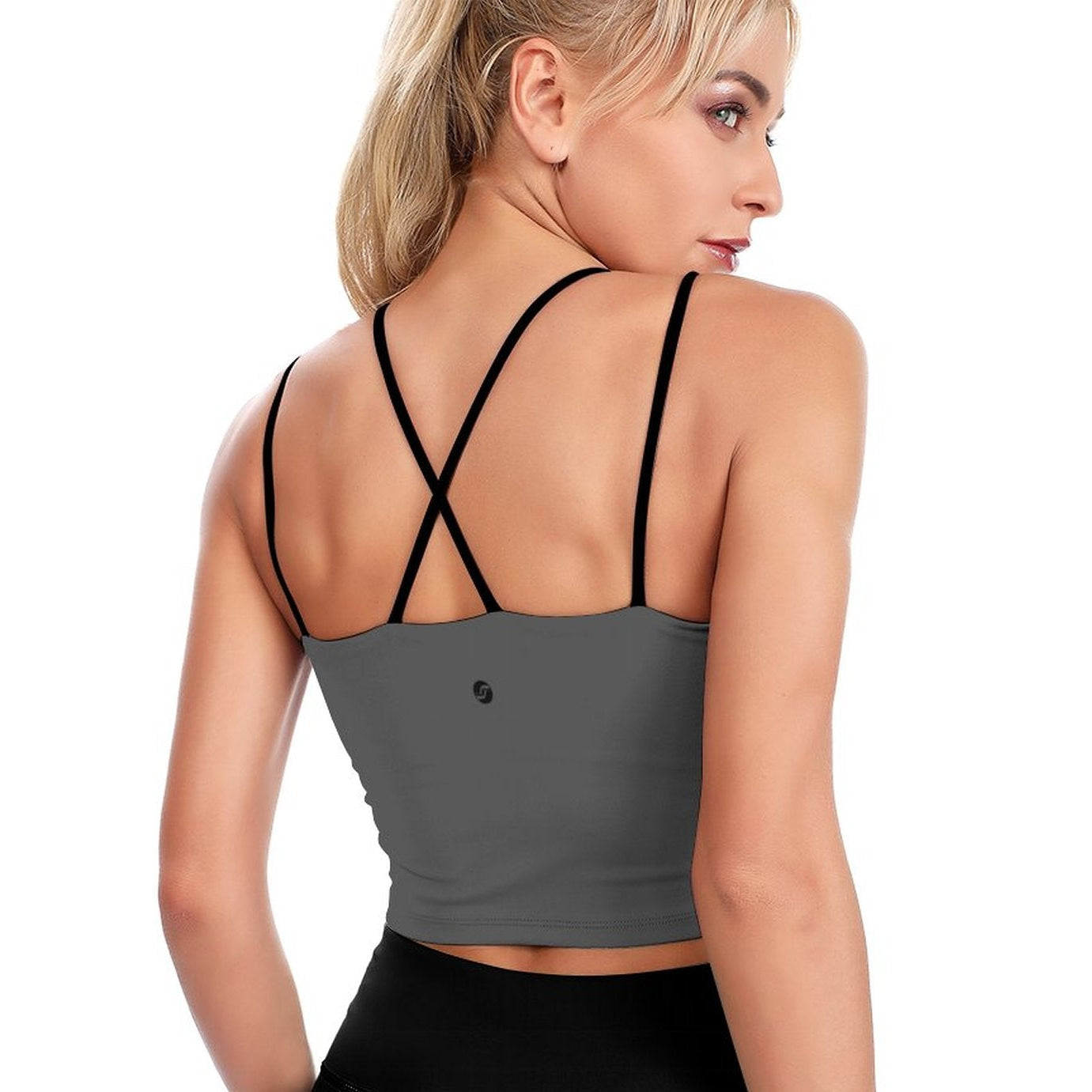 Woman wearing a gray sports bra with thin straps on a white background