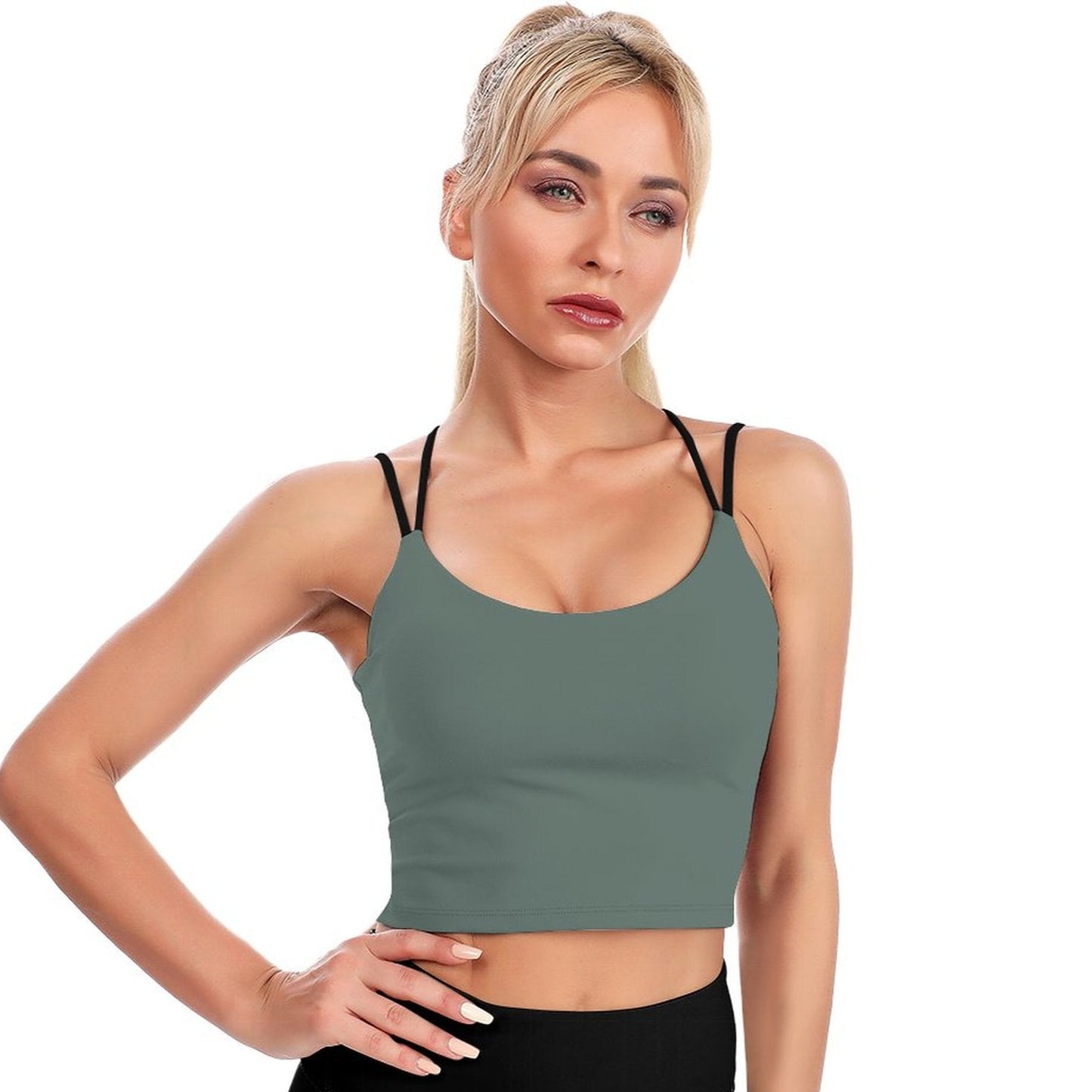 Woman wearing a green sports bra and black leggings on a white background