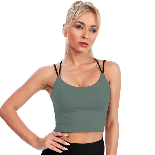 Woman wearing a green sports bra and black leggings on a white background