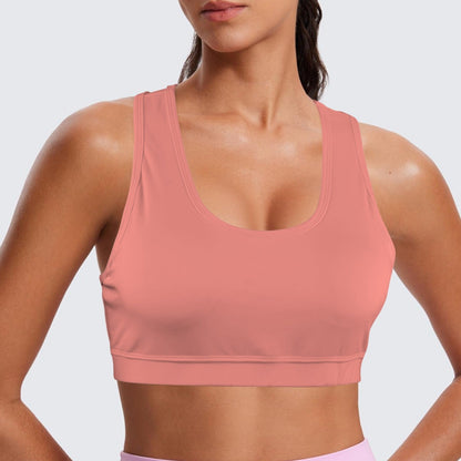 Person wearing a pink sports bra and pink leggings on a light gray background