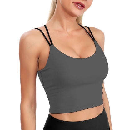 Woman wearing a gray sports bra and black leggings on a white background