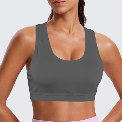 Person wearing a gray sports bra and pink leggings on a light gray background