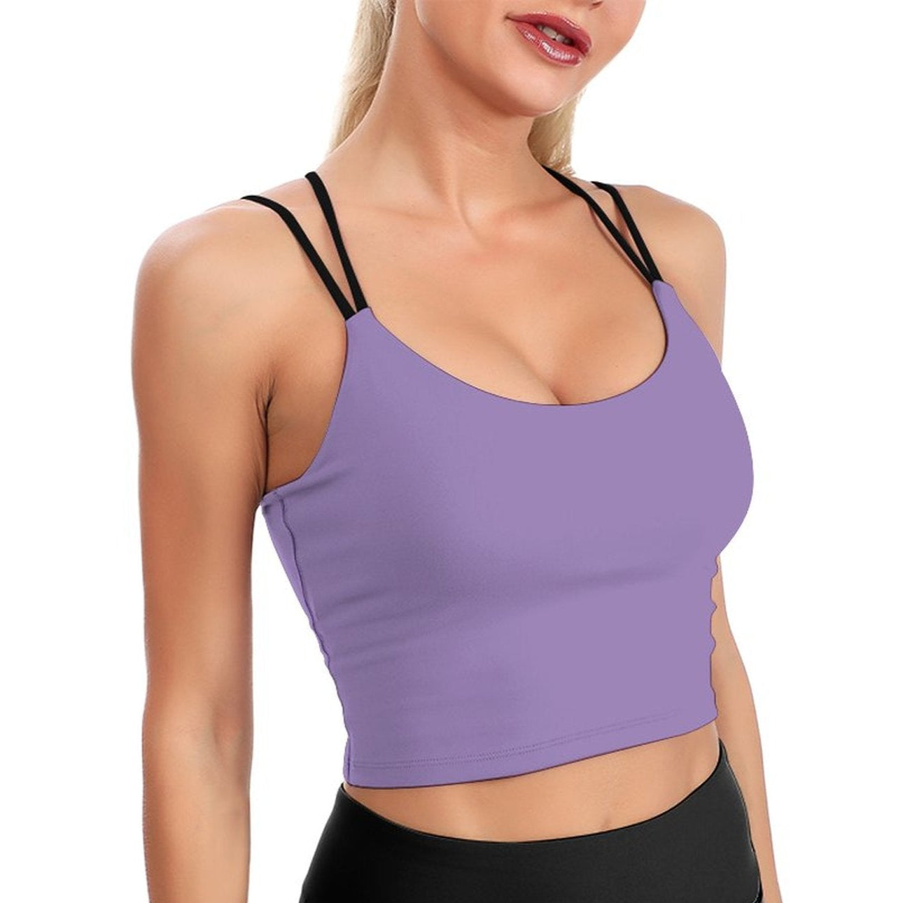 Woman wearing a purple sports bra and black leggings on a white background