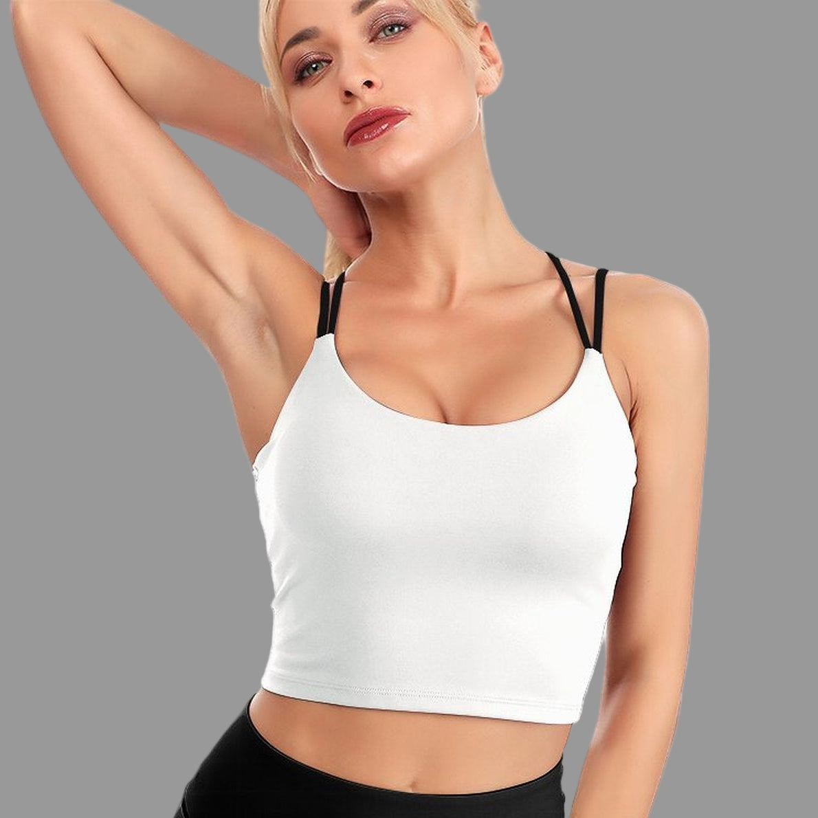 Woman wearing a white crop top and black leggings on a white background