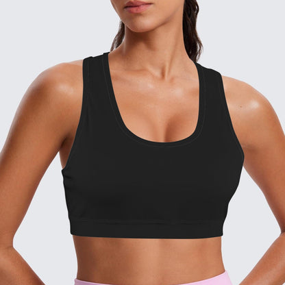 Person wearing a black sports bra and pink leggings on a light gray background