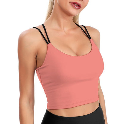 Woman wearing a pink sports bra and black leggings on a white background