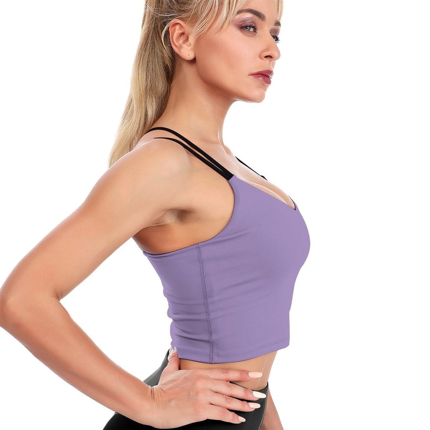 Woman wearing a purple sports bra and black leggings on a white background