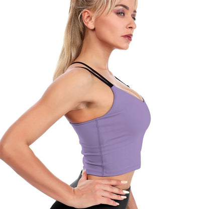 Woman wearing a purple sports bra and black leggings on a white background