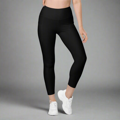 Person wearing black leggings and white sneakers on a gray background