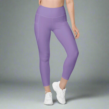 Person wearing purple leggings and white sneakers on a gray background