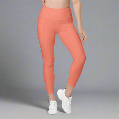 Coral leggings worn by a person on a gray background