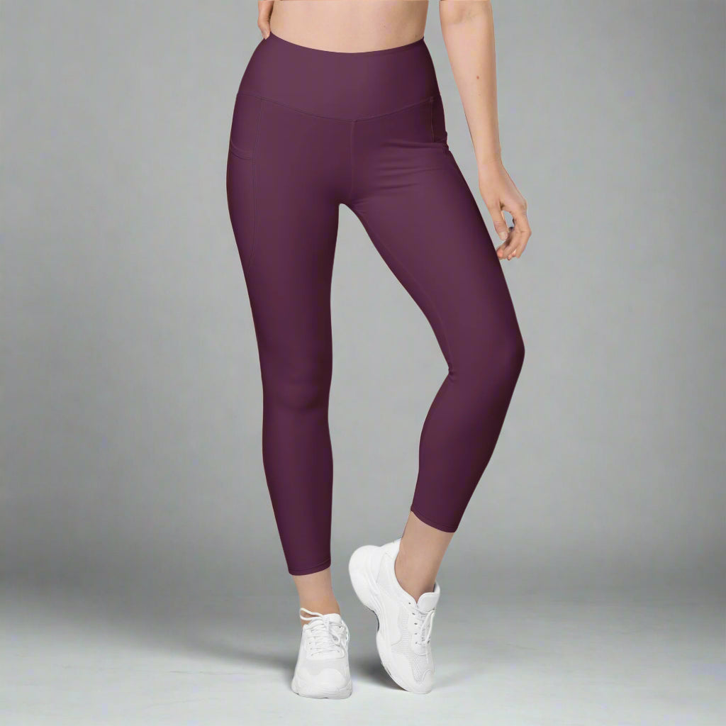 Person wearing purple leggings and white sneakers on a gray background