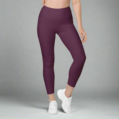 Person wearing purple leggings and white sneakers on a gray background