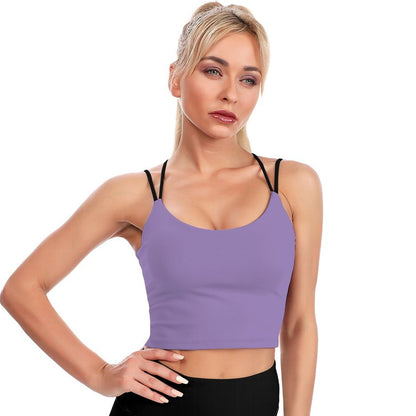 Woman wearing a purple sports bra and black leggings on a white background