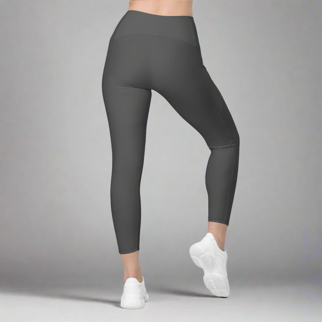 Dark gray leggings worn by a person on a gray background