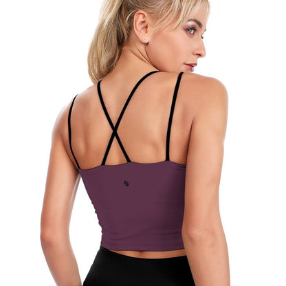 Woman wearing a purple sports bra with black straps on a white background