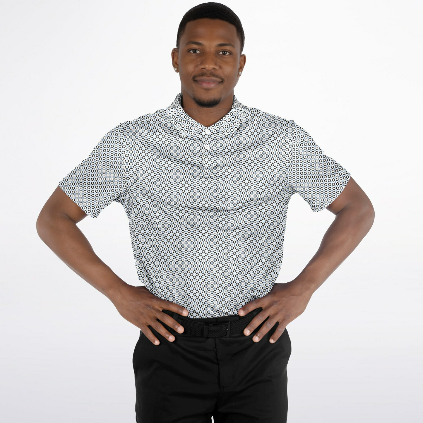 Man wearing a patterned short-sleeve  polo shirt and black pants on a white background