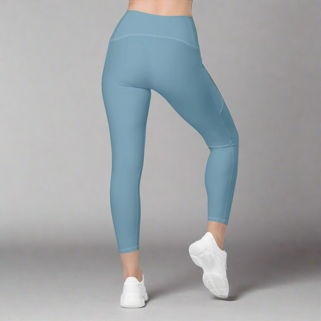 Blue leggings worn by a person on a gray background